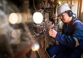 Ein Ingenieur überprüft verschiedene Sensoren an einem großen Motor