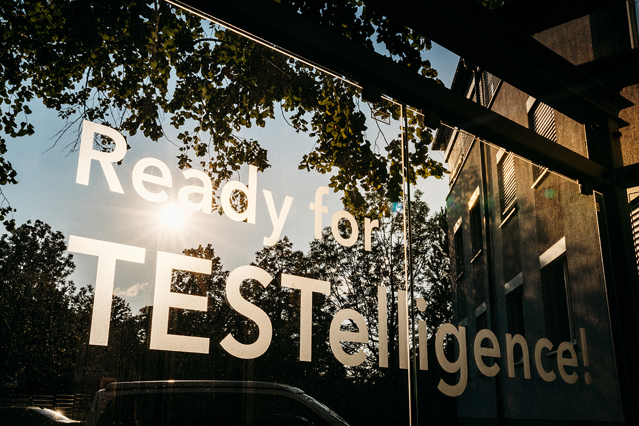 Picture of the claim “Ready for TESTelligence!” taken at the SPEKTRA headquarters in front of the setting sun.